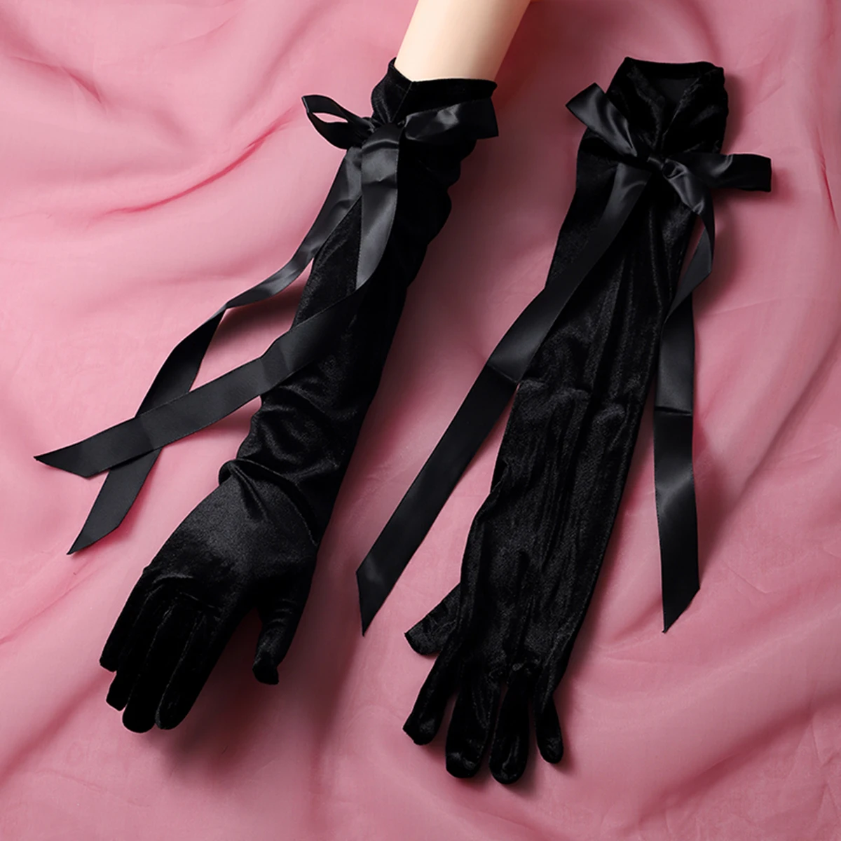 A pair of black gloves with ribbon embellishments in a finger style and elbow length, suitable as accessories for bride weddings