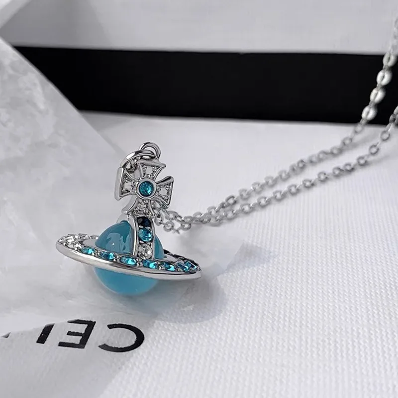 กล่องของขวัญที่เต็มไปด้วยสร้อยคอ UFO ดาวเสาร์สีน้ําเงินเพชรในการออกแบบระดับไฮเอนด์ให้ความรู้สึกห่วงโซ่กระดูกไหปลาร้าของดาวเคราะห์ลึกลับ