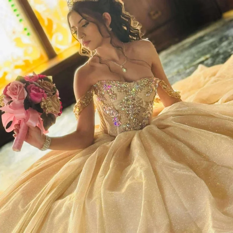 

Блестящие золотые платья Quinceanera цвета шампанского по индивидуальному заказу с открытыми плечами и кристаллами с бантом и длинным хвостом Vestido 15, Quinceanera