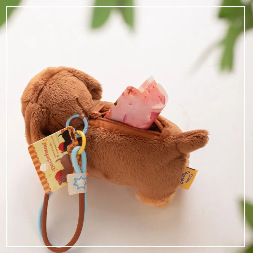 Cute plush dachshund dog keychain and furry puppy bag pendant hanging from a backpack handle.