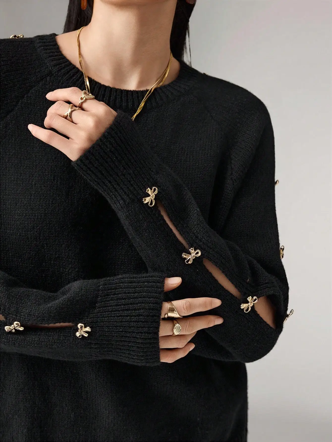 

Женский черный вязаный пуловер с золотым металлическим бантом, рукавами реглан, круглым вырезом