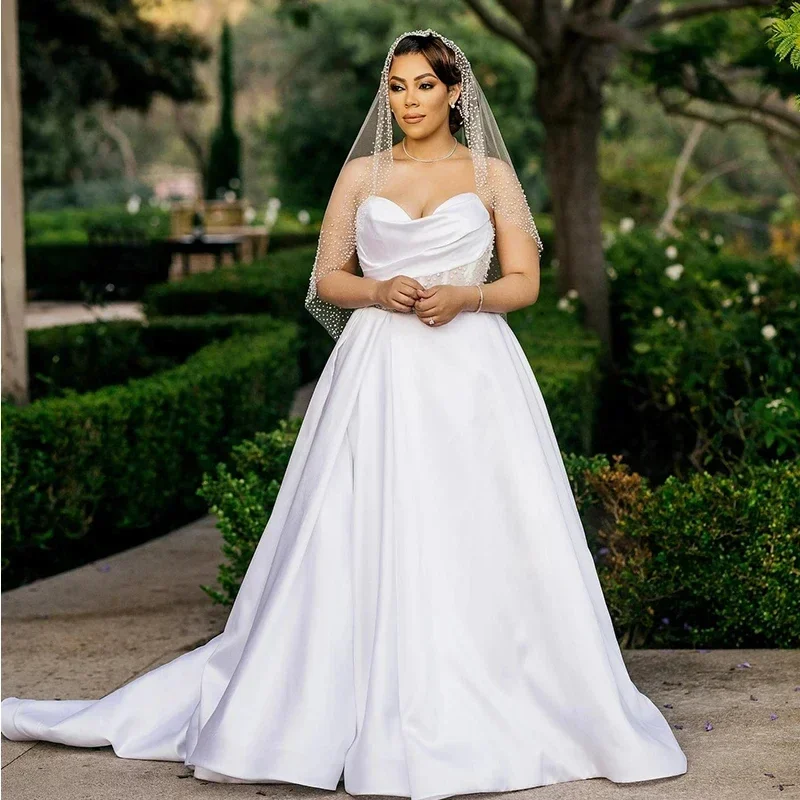 ชุดแต่งงานทรงเอไลน์แบบซีทรูประดับลูกปัดปี 2025 แบบสั่งตัดได้ ชุดเจ้าสาวแบบหวาน ผ้าซาติน สไตล์สวน แอฟริกัน