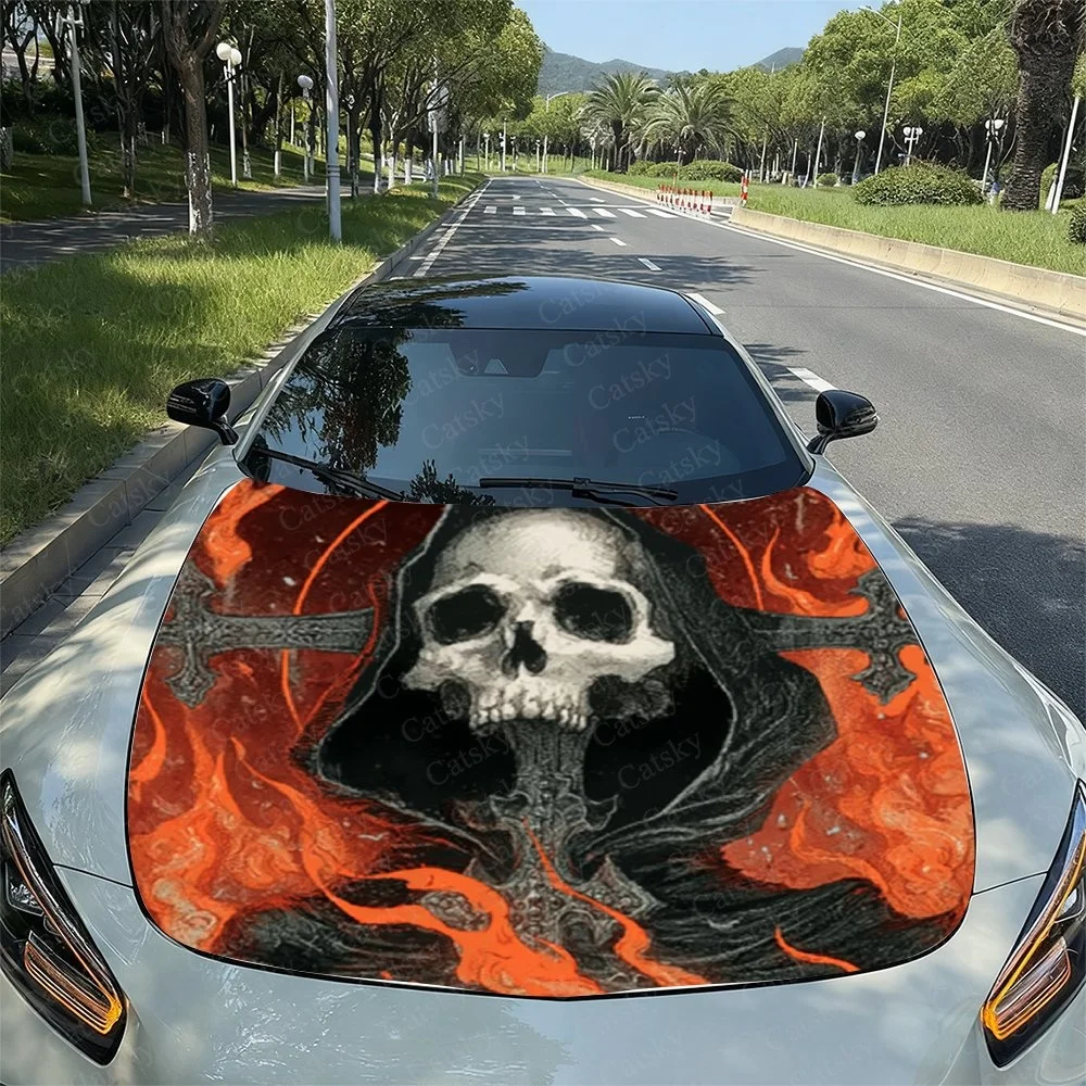 This striking car hood design features a menacing skull in a hooded cloak, surrounded by fiery orange flames and intricate black