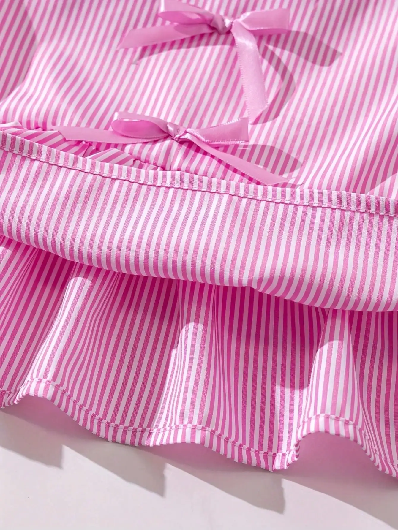 Modisches zweiteiliges Set für Mädchen: rosa-weiß gestreifter Rundhalspullover mit Schnürung, Schleife und Rüschenrand + rosa gestreifte Schmetterlings-Shorts. – Detail 9