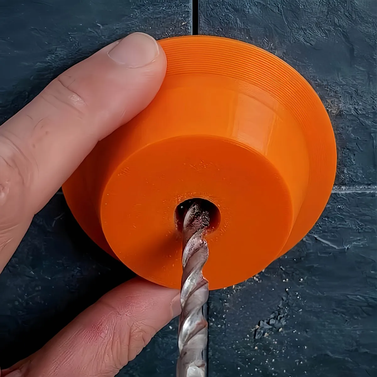 Circular electric drill dust collector with central guide hole, used as a dust shield for drilling holes in walls and ceilings