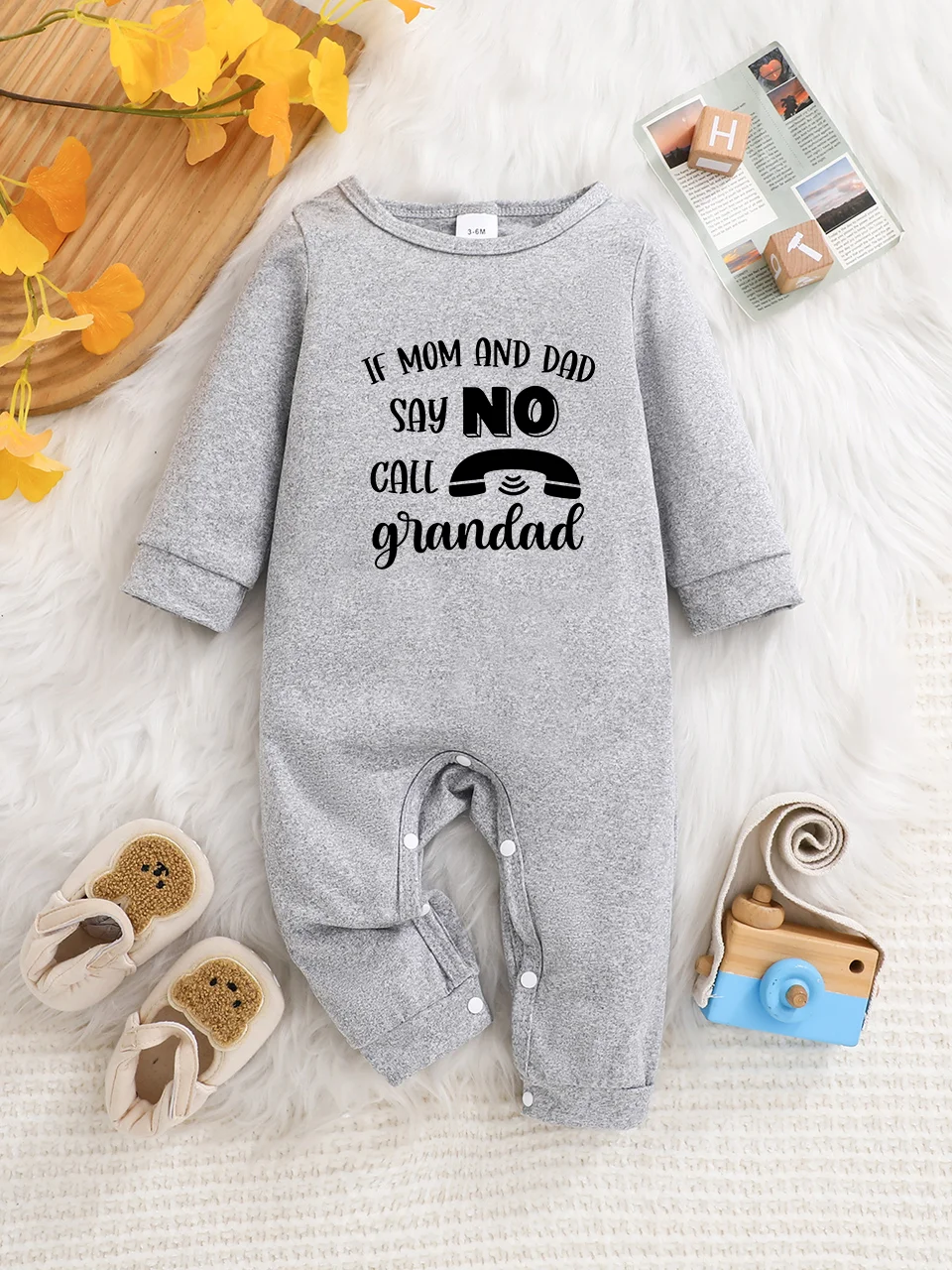 Ein langärmeliger Baby-Strampler mit interessanten Buchstaben-Prints. Es verfügt über ein Knopfverschluss-Design für einfaches An- und Ausziehen.