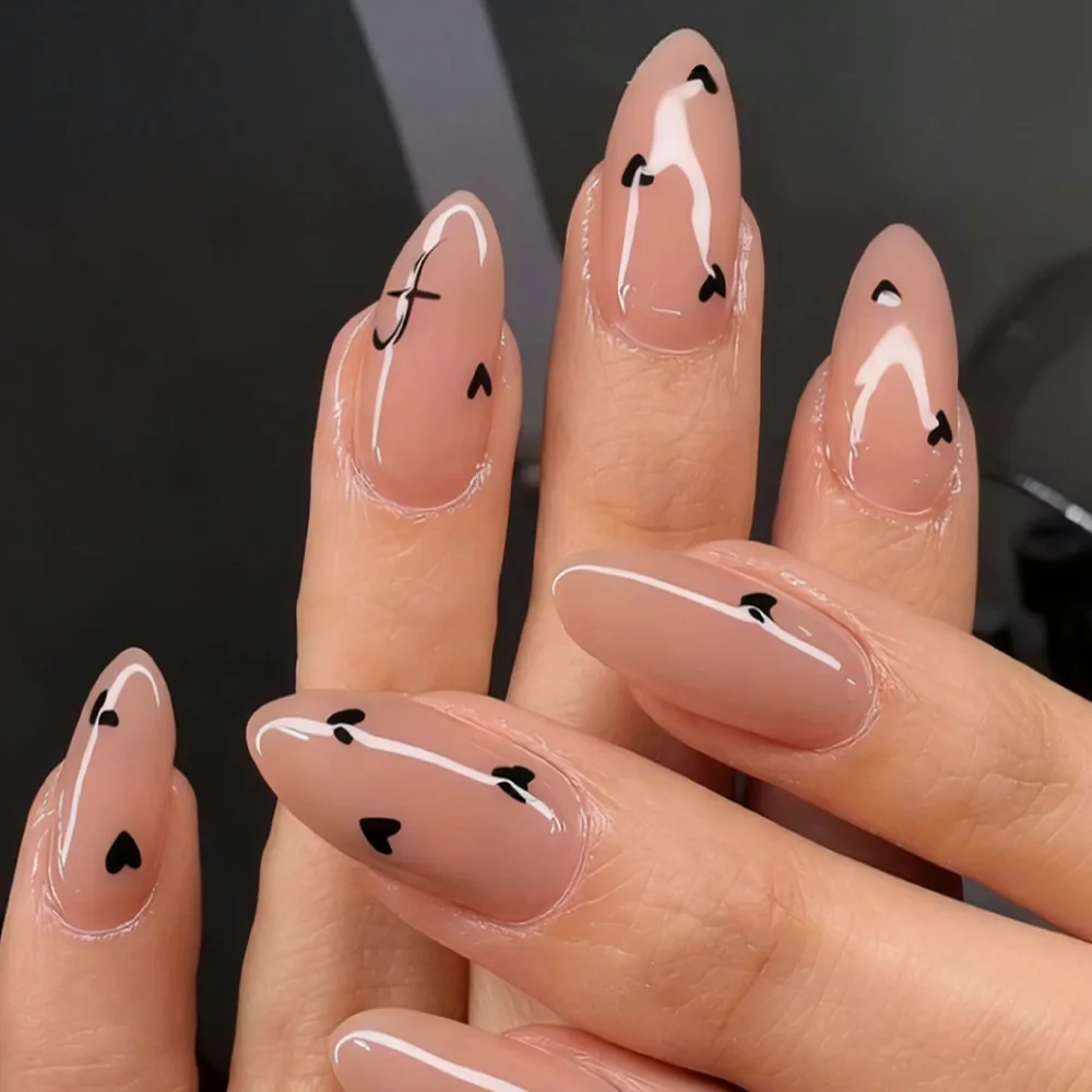 أظافر صناعية متوسطة اللوز باللون البيج مع تصميمات قلب وأحرف قلب وأسود وأحرف لعيد الحب اضغط على مجموعة فن الأظافر الزائفة