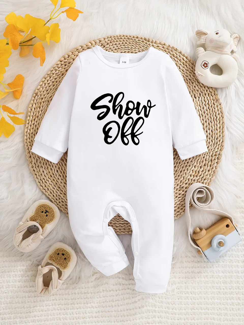 Ein langärmeliger Baby-Strampler mit interessanten Buchstaben-Prints. Es verfügt über ein Knopfverschluss-Design für einfaches An- und Ausziehen, und
