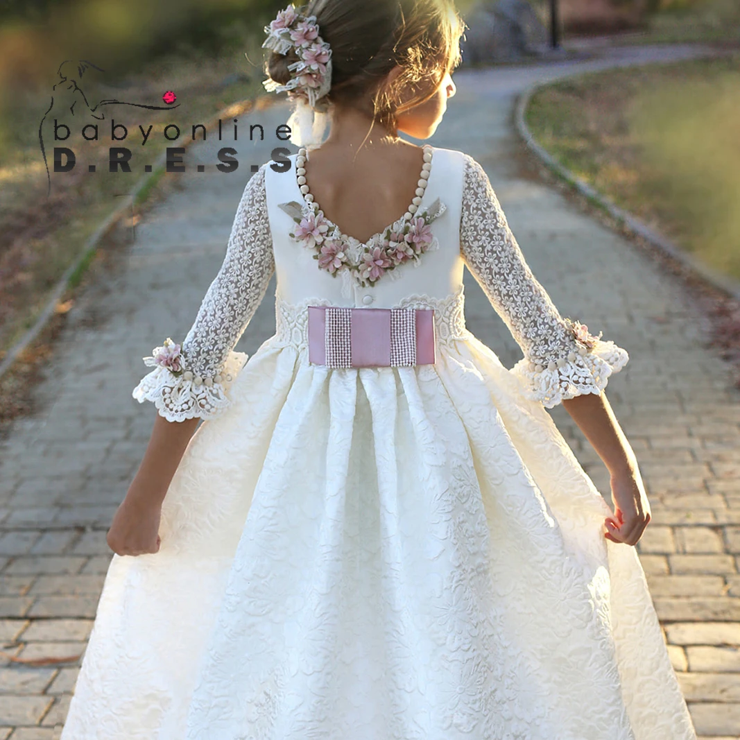 lace first holy communion dresses Catholic Dress Tulle skirt | La Bavetta and mesh fabrics Elegant ballroom silhouette with graceful long train Oversized bow on the back and an elegant oversized floral embellishment at waistline Timeless long whimsical train (optional) Zipper and buttons enclosure on back Fully lined with soft lining for premium comfort and protection Designed and proudly made in Europe Ivory Lace 1st Communion Dress