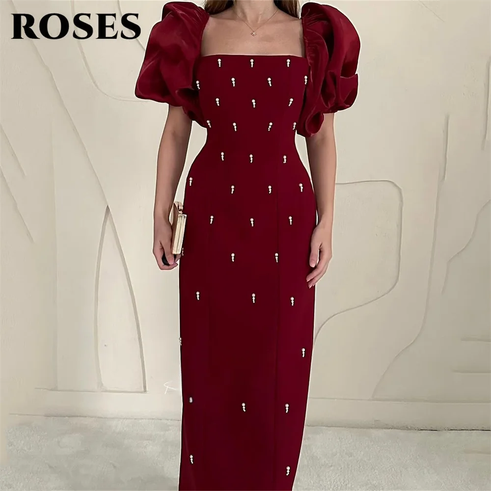 فساتين حفلة موسيقية أنيقة باللون العنابي من ROSES فساتين سهرة بخط عنق مربع وأكمام منتفخة منظمة وتفاصيل متألقة حسب الطلب