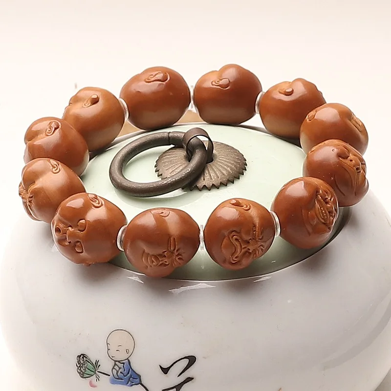 Olive pit charm bracelet, featuring a fun whimsical design, carved from iron ore, with a chubby, happy, and nearly perfectly
