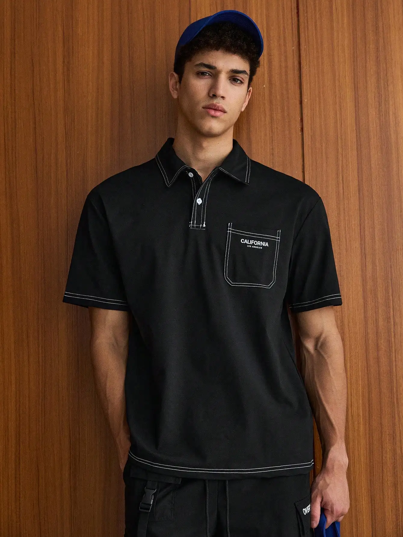 

Черная мужская рубашка-поло свободного кроя с контрастной строчкой и карманом