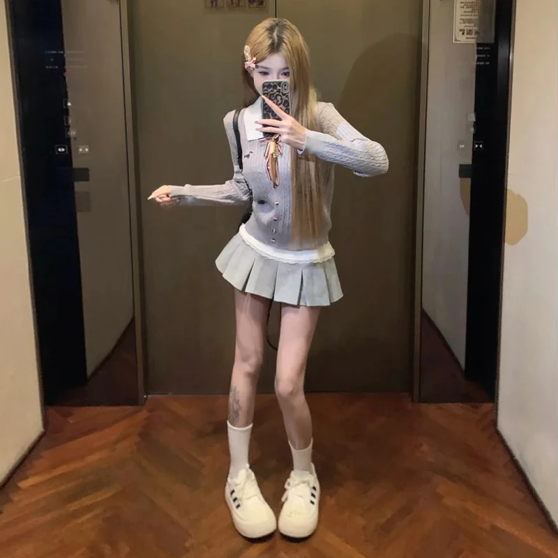 

Корейский вязаный комплект в студенческом стиле из двух предметов: серый топ и плиссированная юбка средней длины. Модный образ для девушек.