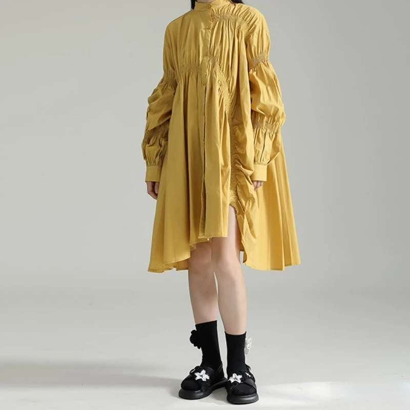 Modna sukienka koszulowa w stylu trendsetterów, luźna, z nieregularnymi plisowanymi bufiastymi rękawami i szerokim dołem.