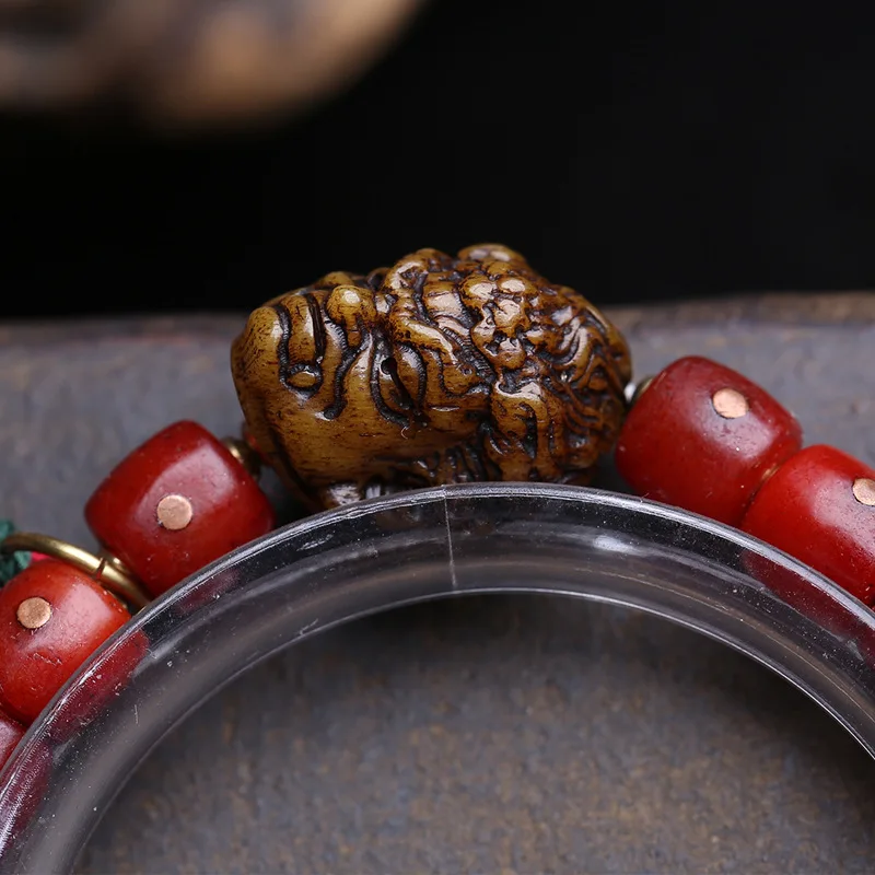 Tibetan-style vintage bracelet with single-loop barrel beads, inlay, yak bone, antler charm, and copper cloud pendan