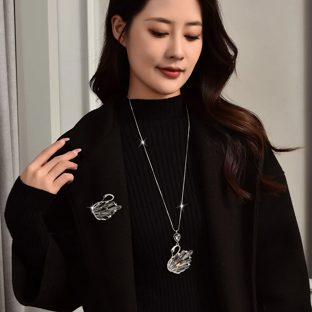 秋冬向けの新しいクリスタルスワンセーターチェーンブローチ。多用途でハイエンドなスタイルを備えています。