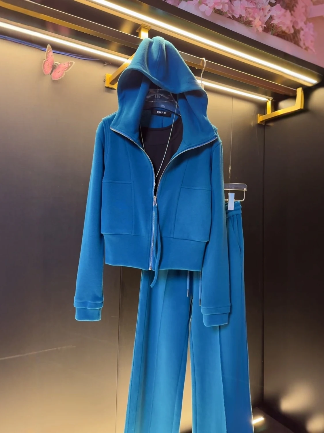 

Комплект из двух предметов: худи свободного кроя синего цвета на молнии и повседневные спортивные брюки прямого кроя. Женская осенняя одежда.