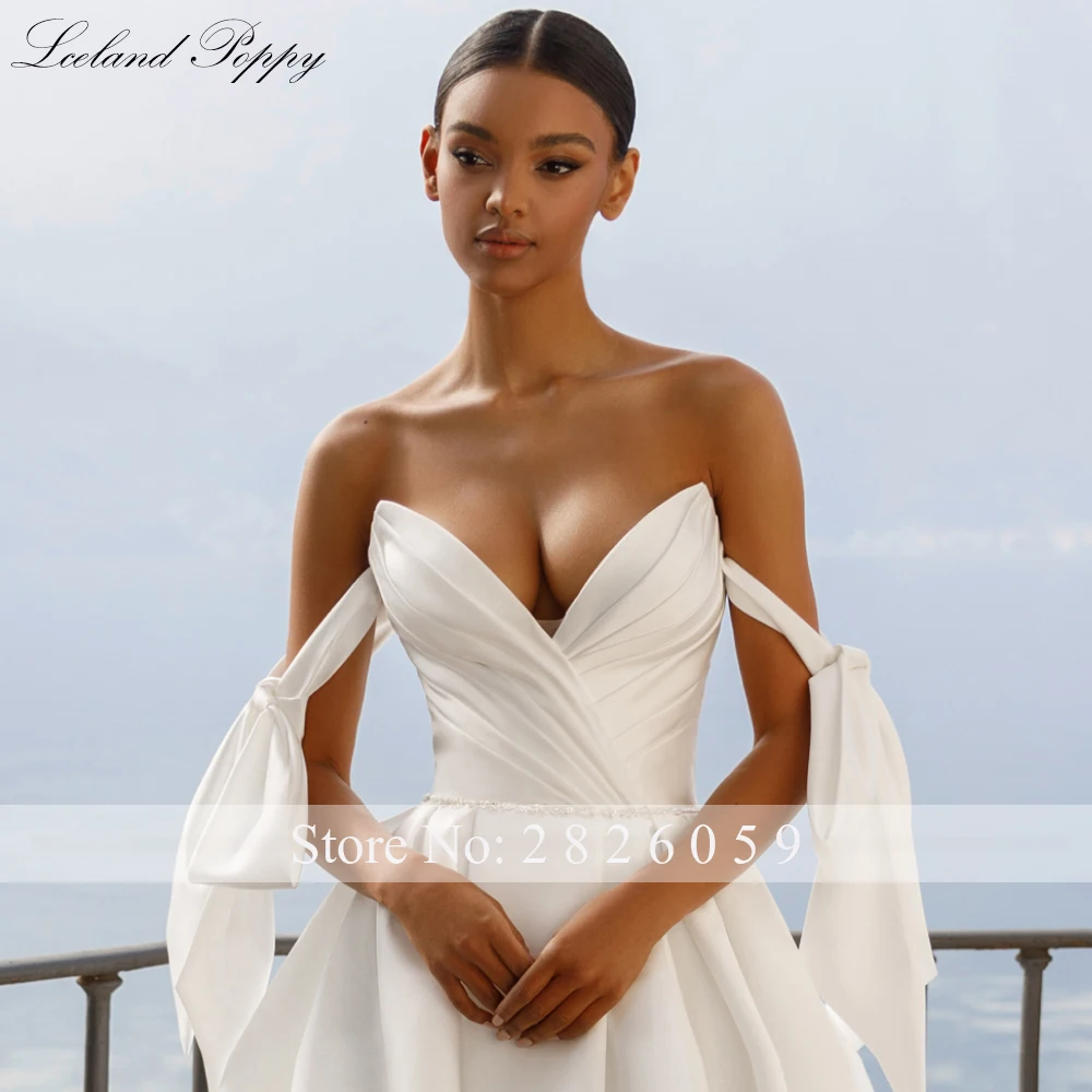 ชุดแต่งงานผ้าซาตินทรงเอไลน์แบบคอวี แขนตกไหล่ ประดับลูกปัด พร้อมชายกระโปรงยาวแบบชาเปล สไตล์ไอซ์แลนด์ป๊อปปี้  แบบสั่งตัดพิเศษ