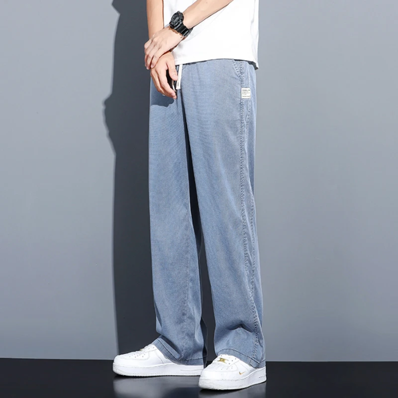 Celana jeans pria musim panas, model longgar potongan lurus, pinggang elastis dengan tali serut, gaya kasual Korea, ukuran besar M-5XL