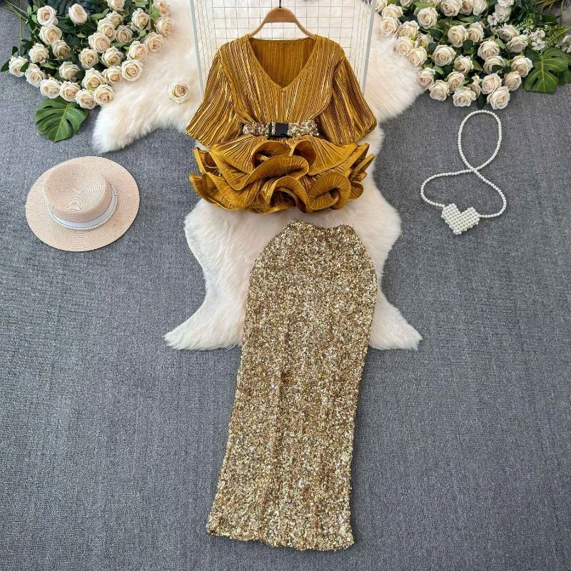 

Модный и элегантный женский комплект из двух предметов: блузка с короткими рукавами-фонариками и V-образным вырезом + юбка с высокой талией и пайетками.