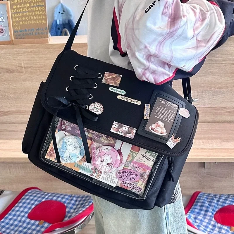 

Y2K Japanese Style Ita Bag – Black Lace-Up Messenger Shoulder Bag with Clear Pocket for Anime Pins, Badges, and Keychains