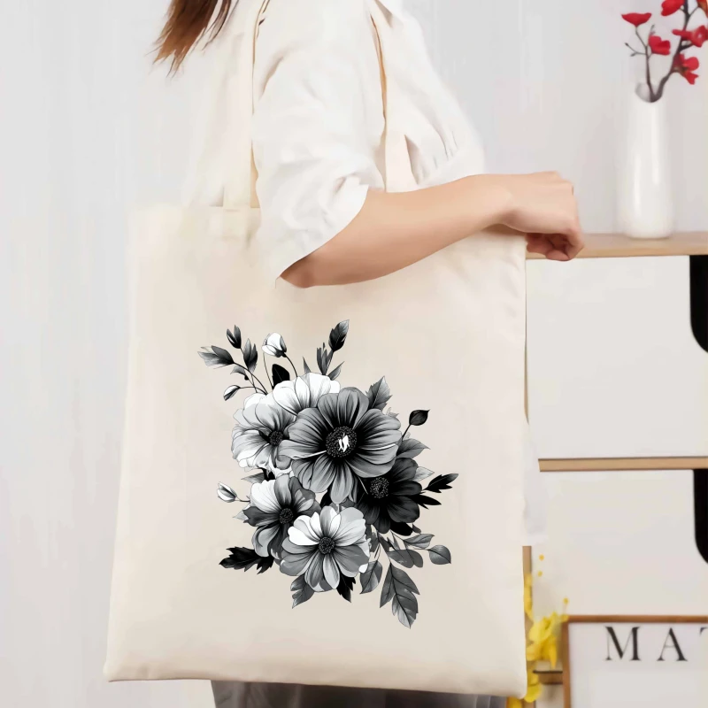 Sac à main en toile à imprimé floral crème, motif floral noir et blanc, adapté à un usage quotidien et au shopping.