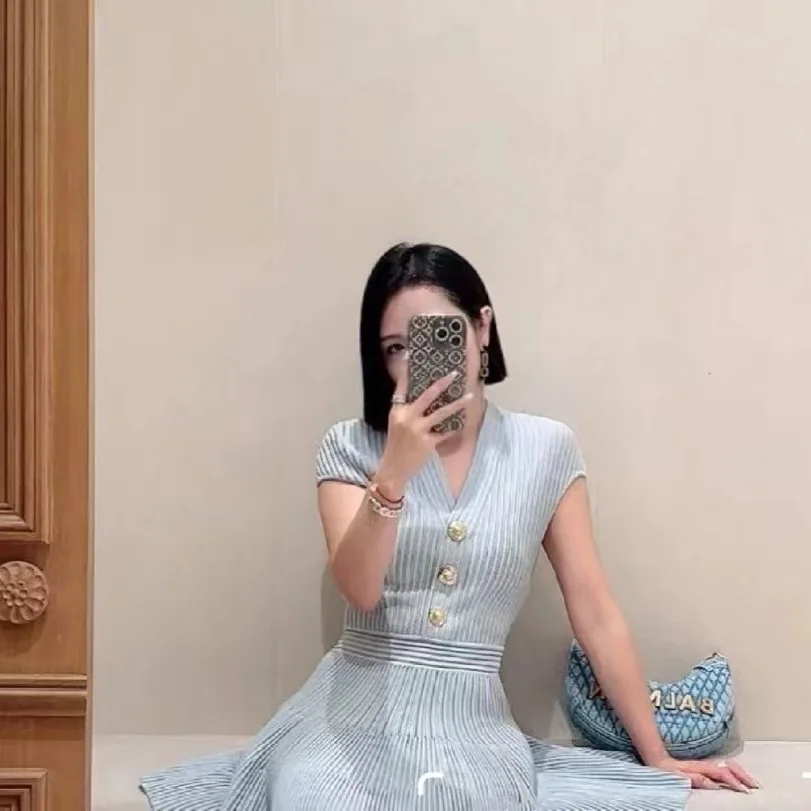 Dit is een nieuwe herfststijl van een heavy metal gesp, taille-cincerende en afslankende mouwloze gebreide jurk met V-hals van een socialite