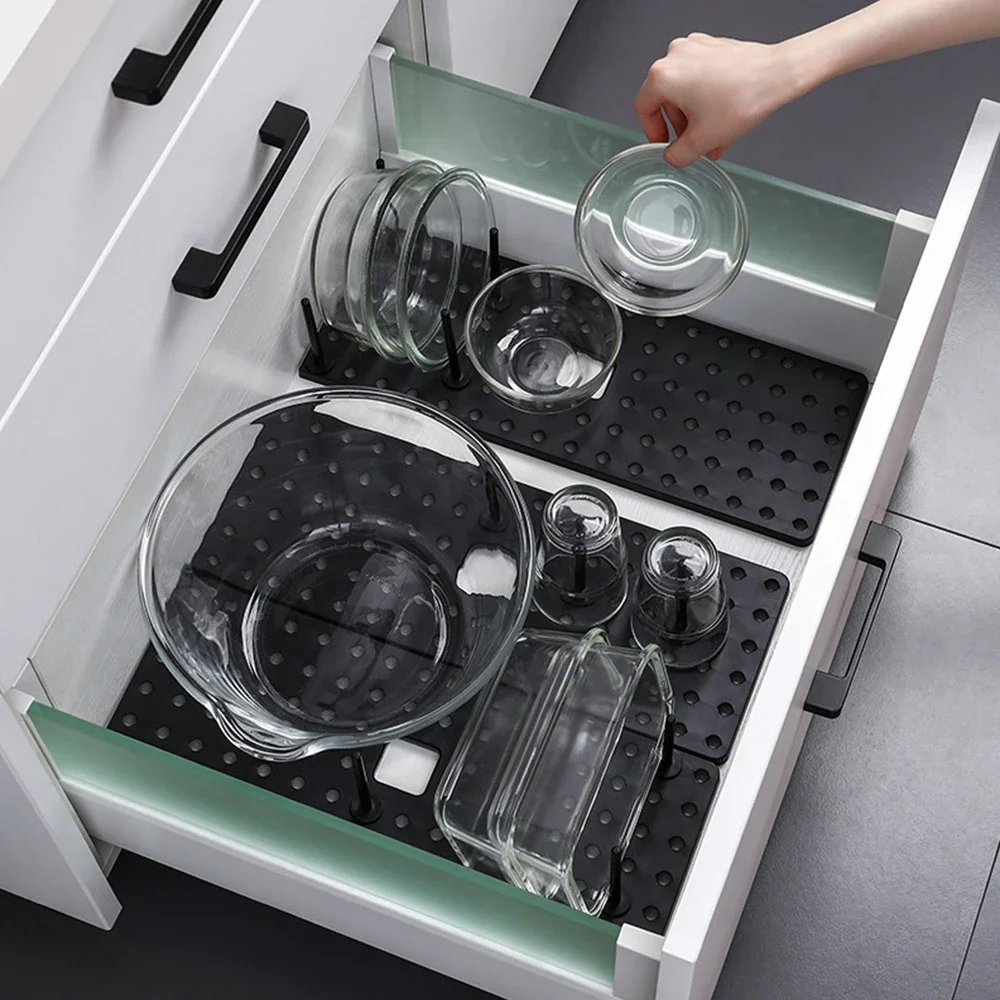 Dish rack in use on kitchen counter holding plates bowls and pot lids in separated slots