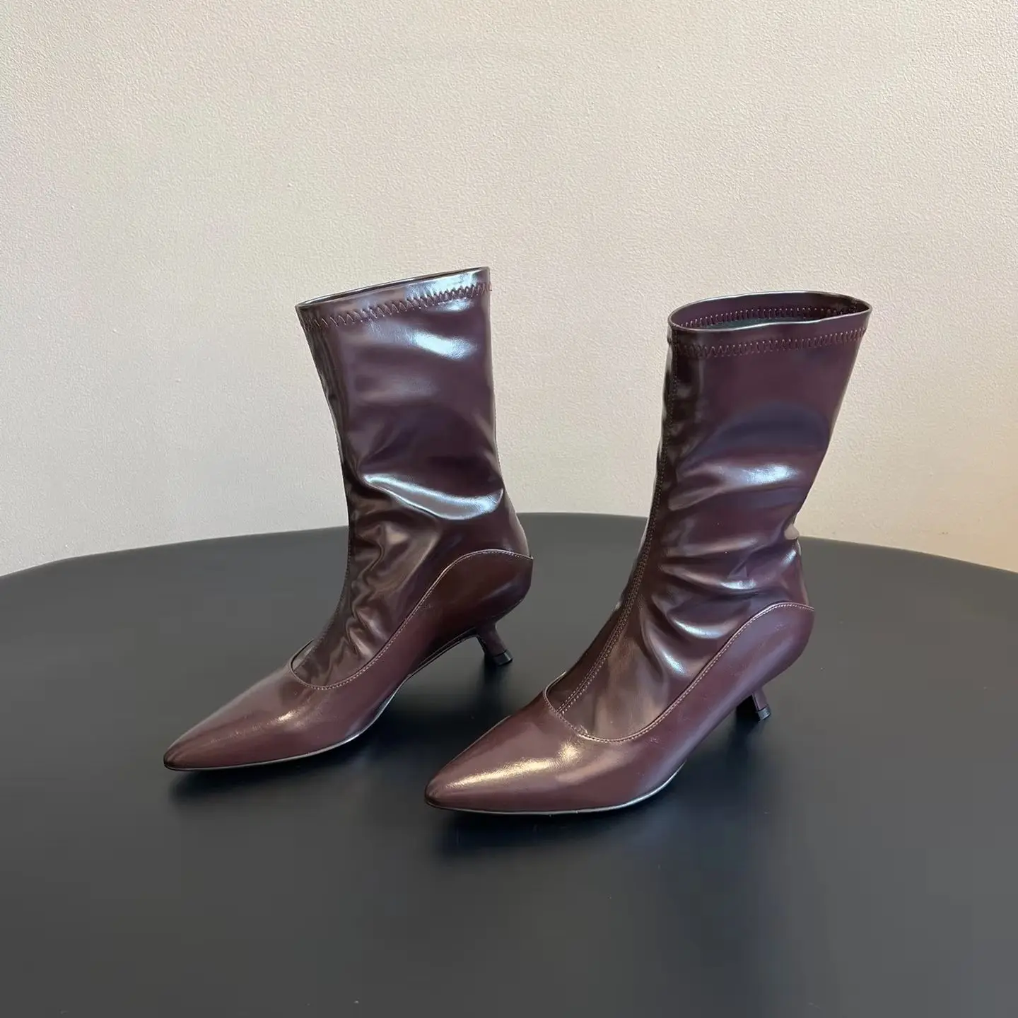 

Новейший дизайн: 26-дюймовые новые блестящие кожаные короткие сапоги с декоративным эффектом в форме ноги черного и бордового цвета.