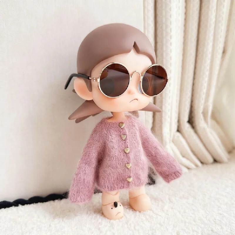 For the Zsiga doll dress it features a stylish pair of sunglasses a pink sweater and a cute design reminiscent of a grandma.