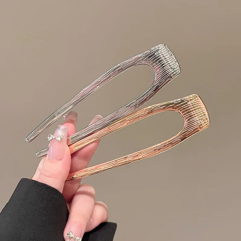 금속 참 장식의 꼬임 패턴과 매끄러운 교차로 엮인 U자형 브로치가 세련된 드레싱 스타일을 빛내며, 독특하면서도 고급스러운 느낌을 선사합니다.