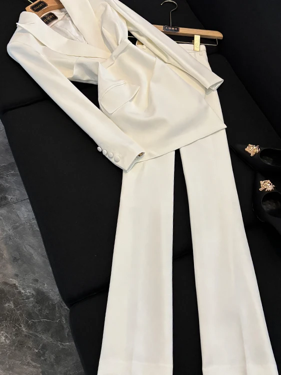 

Белый женский деловой костюм-двойка: приталенный пиджак с длинным рукавом и брюки с широкими штанинами. Дышащий повседневный офисный комплект.