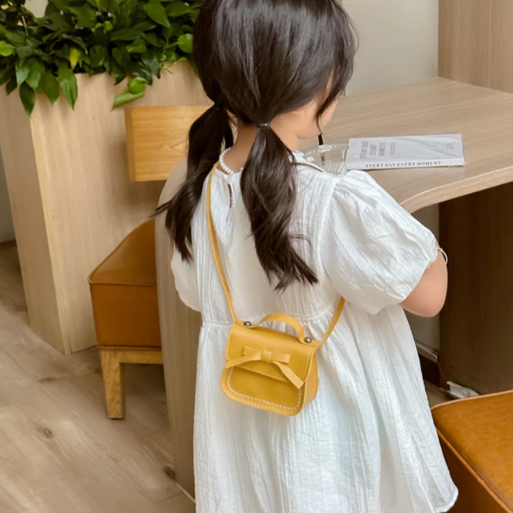 المحمولة بو الجلود القوس حقيبة كتف بلون محفظة نسائية للعملات المعدنية القوس حقيبة كروسبودي محفظة حقيبة يد الأطفال حقيبة صغيرة الشارع الشهير