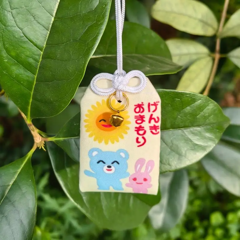 Omamori de moda para karaoke Go Sing, estilo RedBook, amuleto de la suerte con estampado de girasol, oso azul y conejo, y pequeña campana, en bolsita.