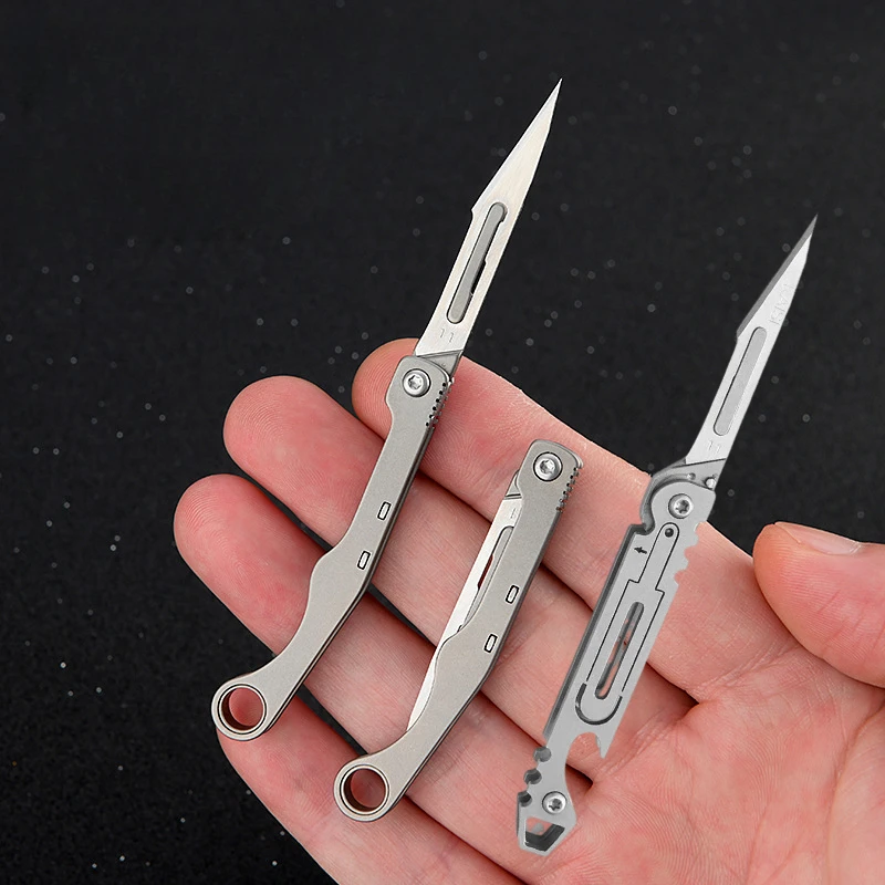 ใหม่ Mini Titanium Alloy มีดพับกลางแจ้ง Camping แบบพกพา EDC มีดมาพร้อมกับใบมีดฟรี 10 ชิ้น