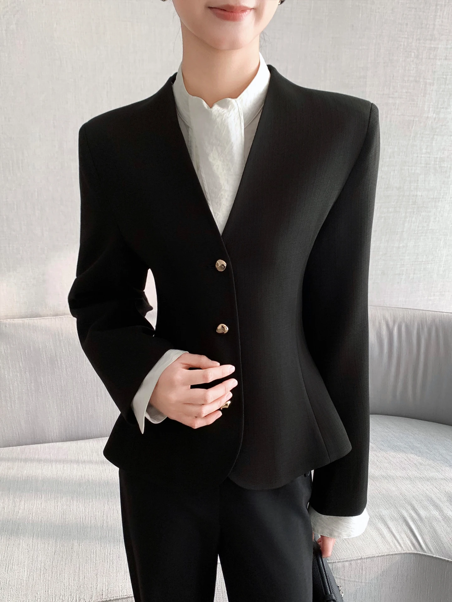 Dopasowany krój, dekolt w serek, długi rękaw, damski żakiet, czarny, z podkreśloną talią, warstwowa odzież wierzchnia, wiosna 2026, modny, uniwersalny.