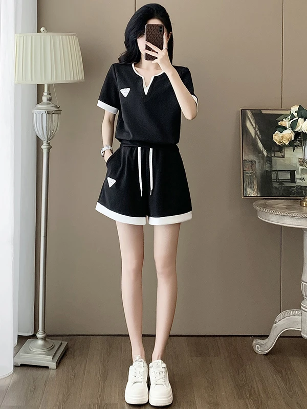 

Модный омолаживающий повседневный спортивный костюм для женщин: летний элегантный комплект из укороченного черного топа с V-образным вырезом и шорт, визуально стройнящий фигуру, две части.