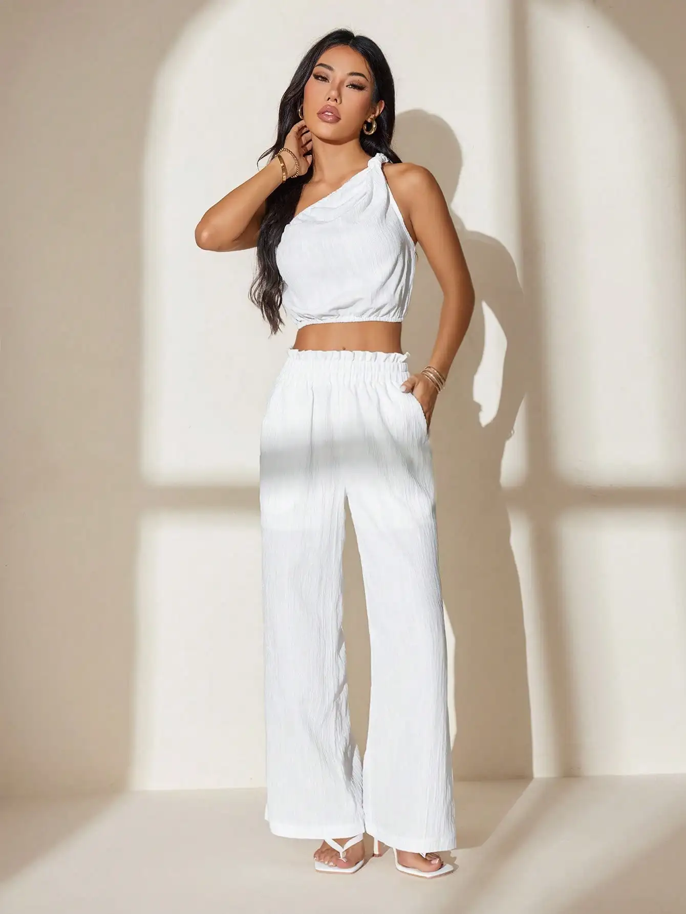 Witte crop top met één schouder en broek met wijde pijpen voor zomerfestivals, strand, vakantie, vrijetijdskleding