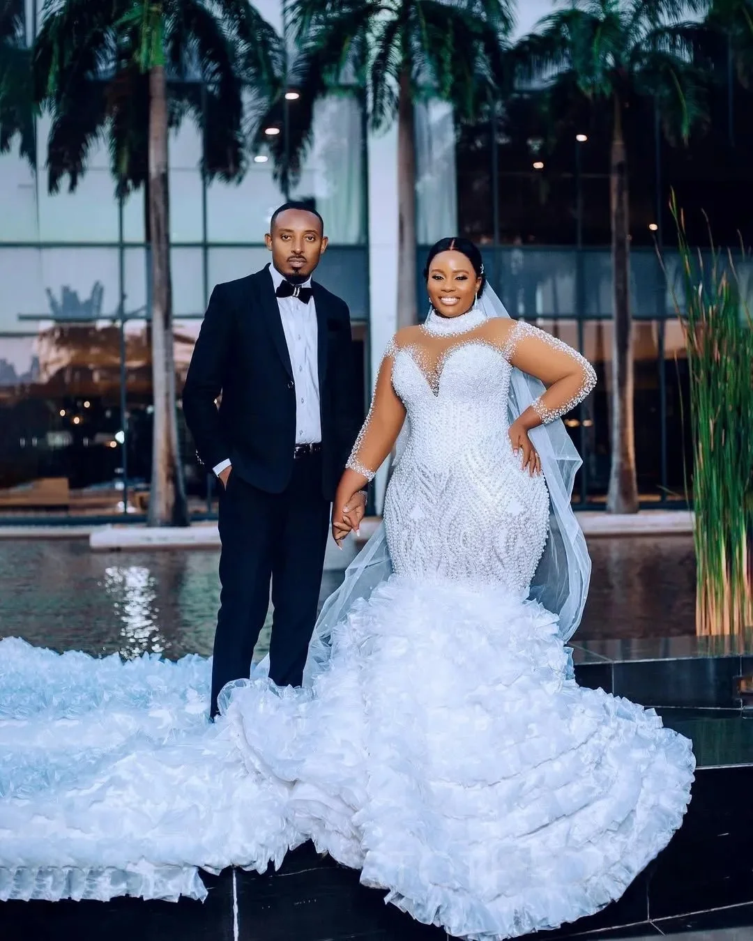 Suknia ślubna na zamówienie, biała, afrykańska, dla panny młodej, krój syreny, długie rękawy, zdobiona perłami i koralikami.