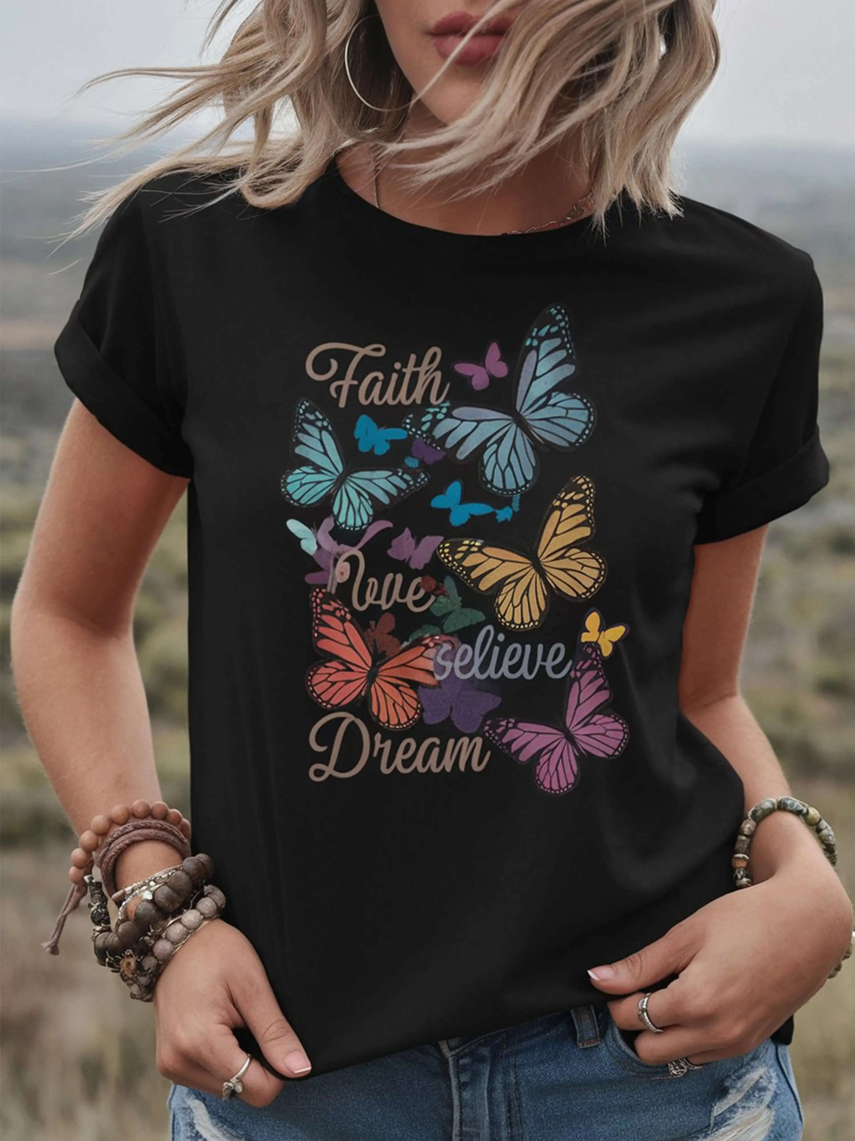 Una maglietta da donna girocollo in cotone con motivi di farfalle colorate e forme geometriche, tessuto a maglia traspirante, regolare