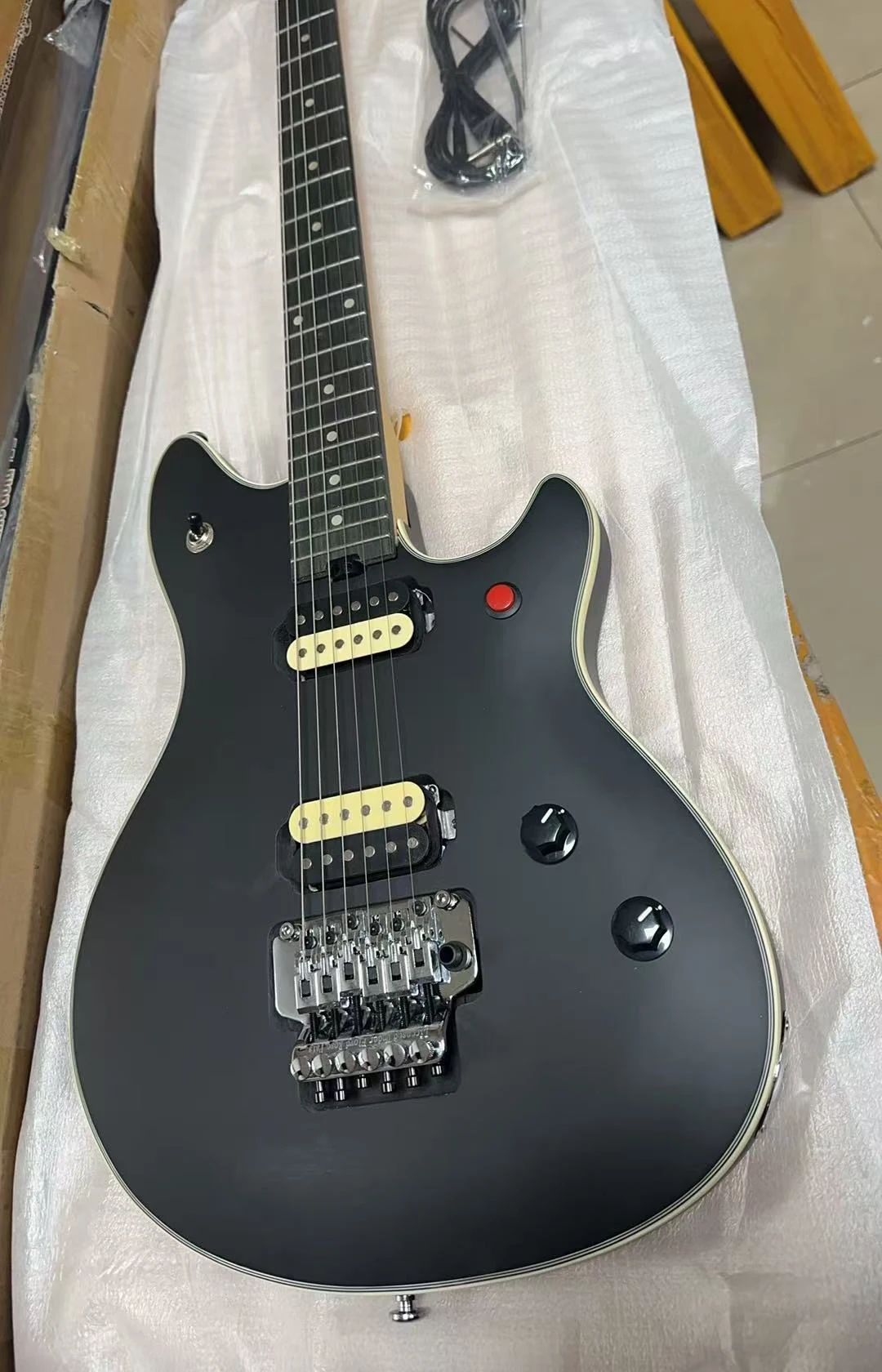 

Гитара 2026 года, модель Hot Special Stealth, матовый черный цвет, тремоло-бридж Floyd Rose, красные ручки.