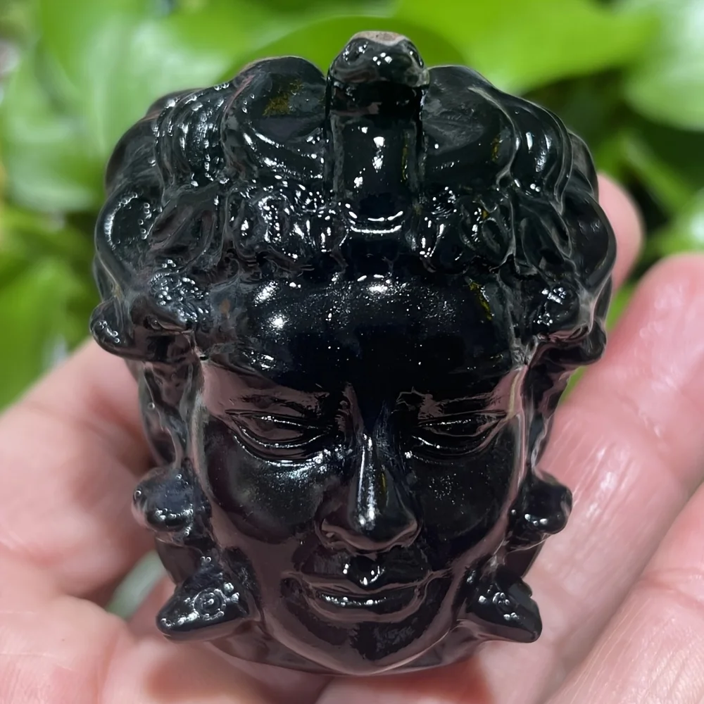 A handcrafted obsidian Medusa head with snake heads | Greek mythology decoration, shimmering gold under UV light， home decor