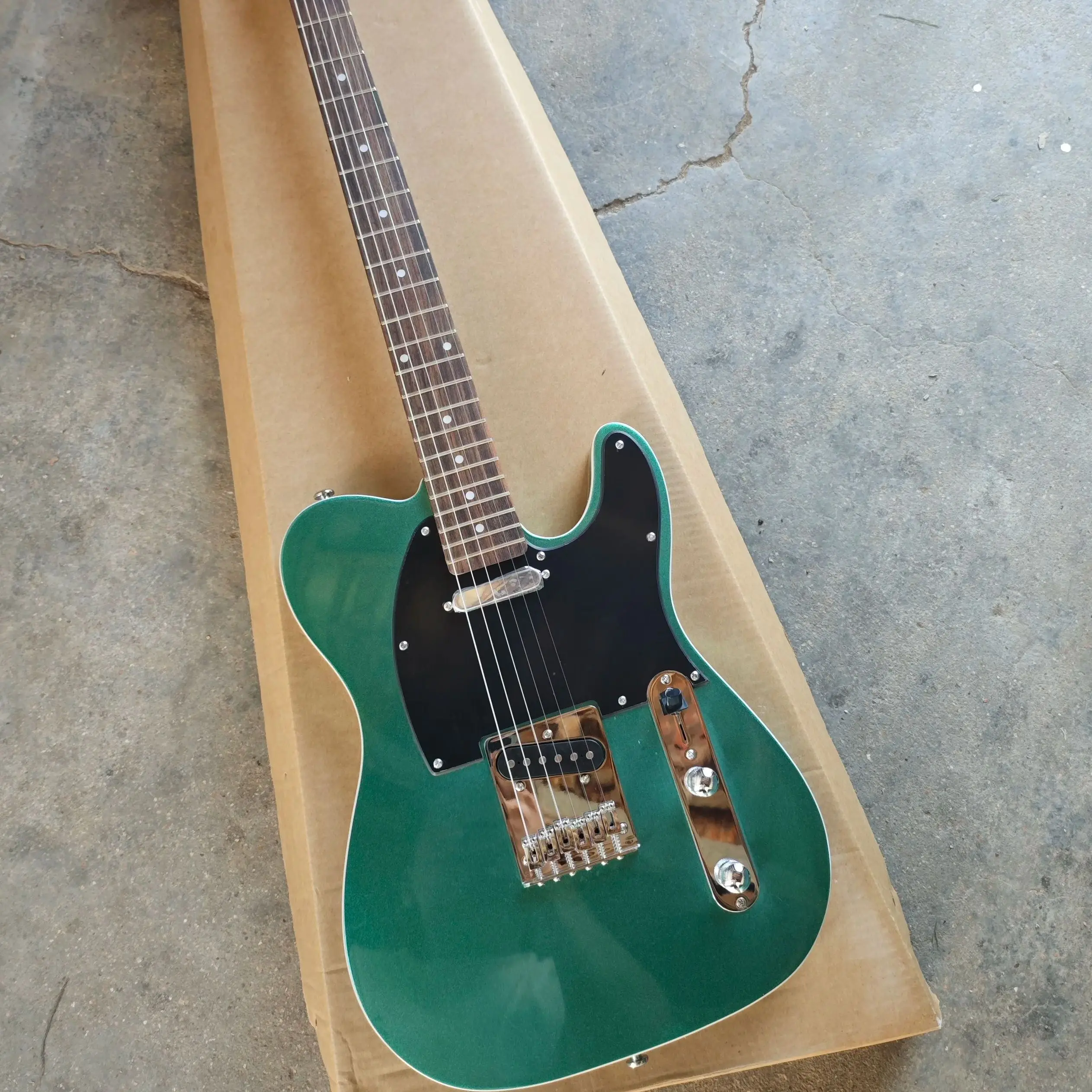 Six string electric guitar with white edging, green silver powder paint finish, black protective plate