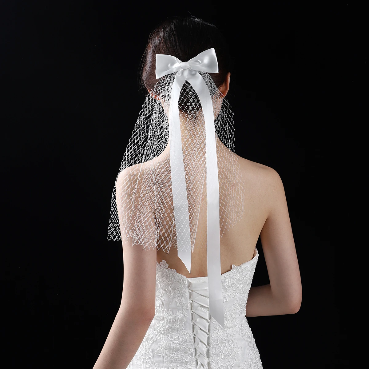 A white elegant bridal veil adorned with a simple bow, shoulder length veil suitable for women's weddings