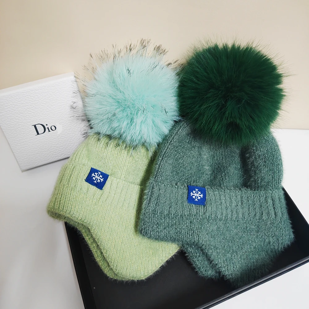 

Hot selling couple ear protection hat candy color scheme fashionable artificial large wool ball knitted hat Christmas skiing