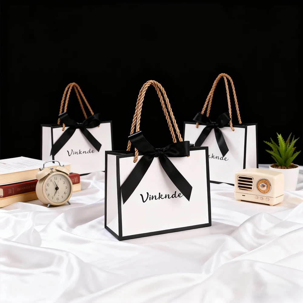 

Роскошный белый бумажный подарочный пакет с черными ленточными ручками с бантом, индивидуальный логотип, идеальная упаковка для ювелирных изделий, серег, парфюмерии, мужские бритвы