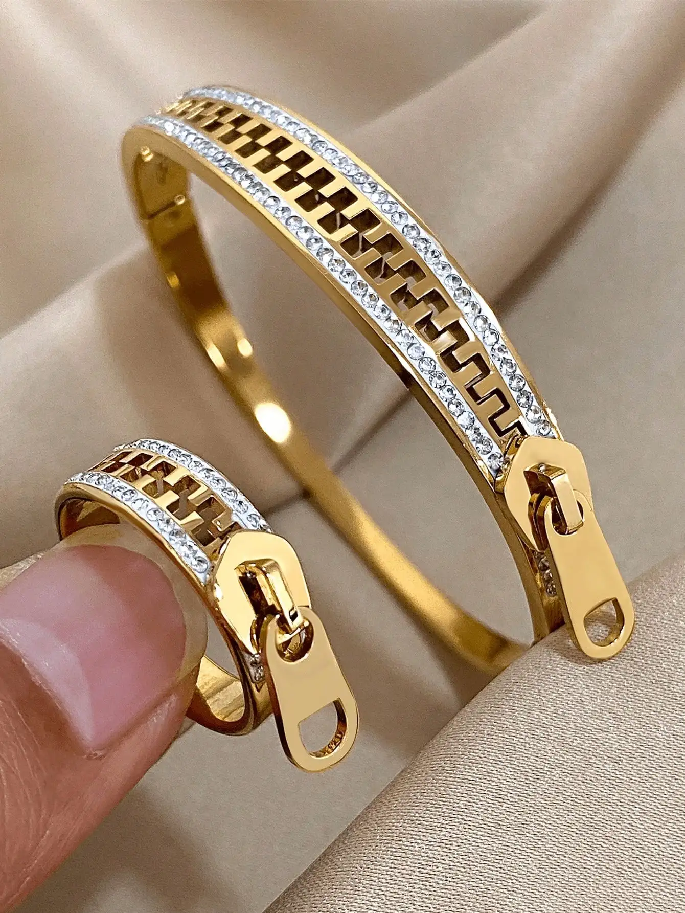 

Набор браслетов и колец золотистого цвета с застежкой-молнией, геометрическими вырезами и кристаллическими вставками