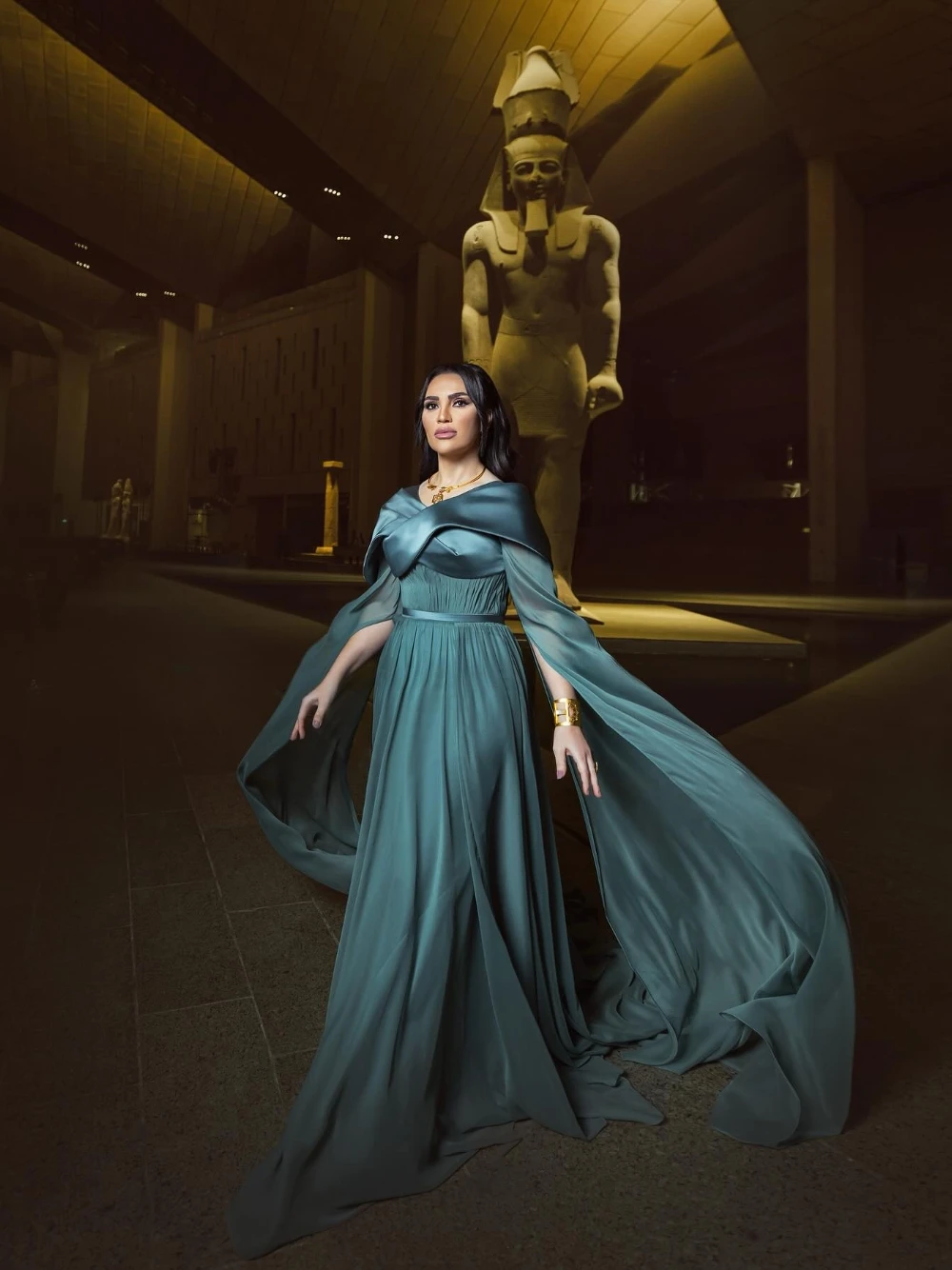 ชุดราตรีสไตล์อียิปต์โบราณสีเขียวอมฟ้า แขนเคป จับจีบ สง่างาม แบบอาหรับ พร้อมชายกระโปรงยาวแบบดราม่า สามารถสั่งตัดได้