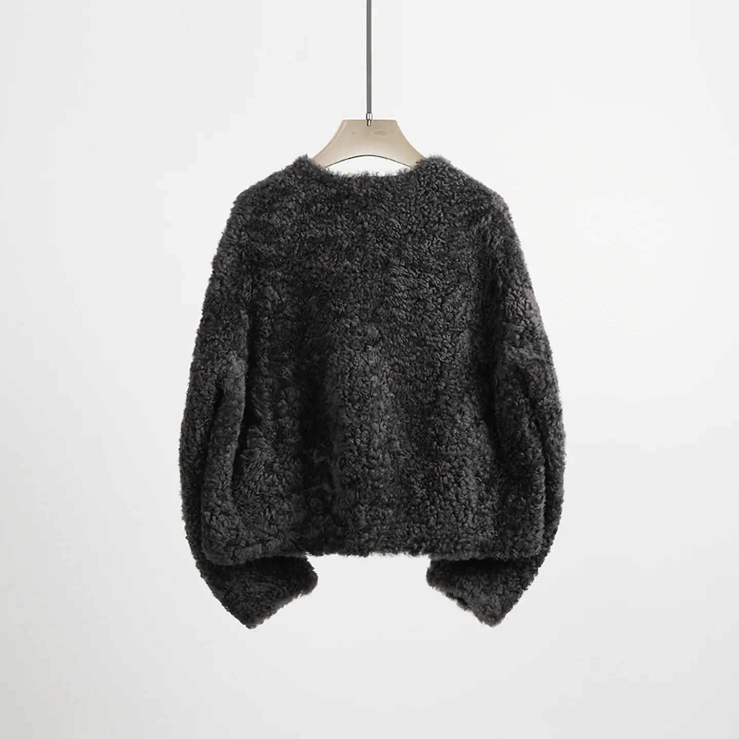 Abrigo de piel reversible recortado y holgado con cuello redondo de punto de lana y piel de oveja de primera calidad ultra minimalista