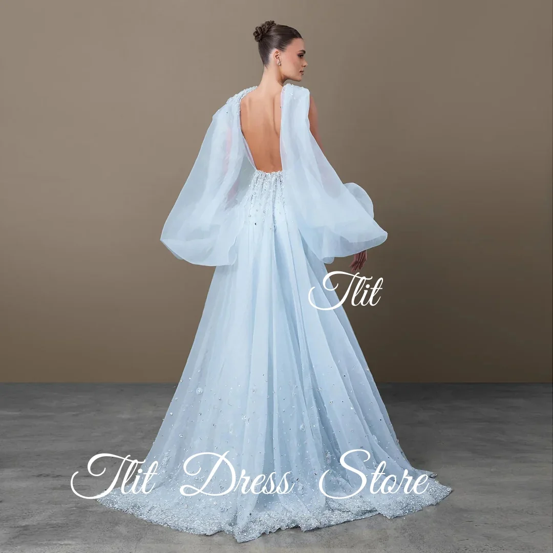 فستان سهرة أنيق من TLIT باللون الأزرق والحرير والساتان حورية البحر مع سترة من التول وأكمام منتفخة وقطار سويب كريستالي مع كريستالفساتين